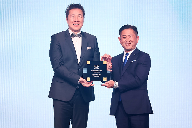 写真：受賞盾を持つ川合 俊一会長（日本バレーボール協会）と久保田 剛代表（大阪ブルテオン）