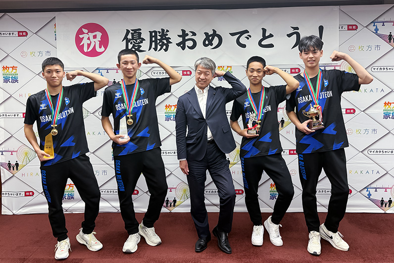 写真:ブルテオンポーズをする伏見市長と選手たち