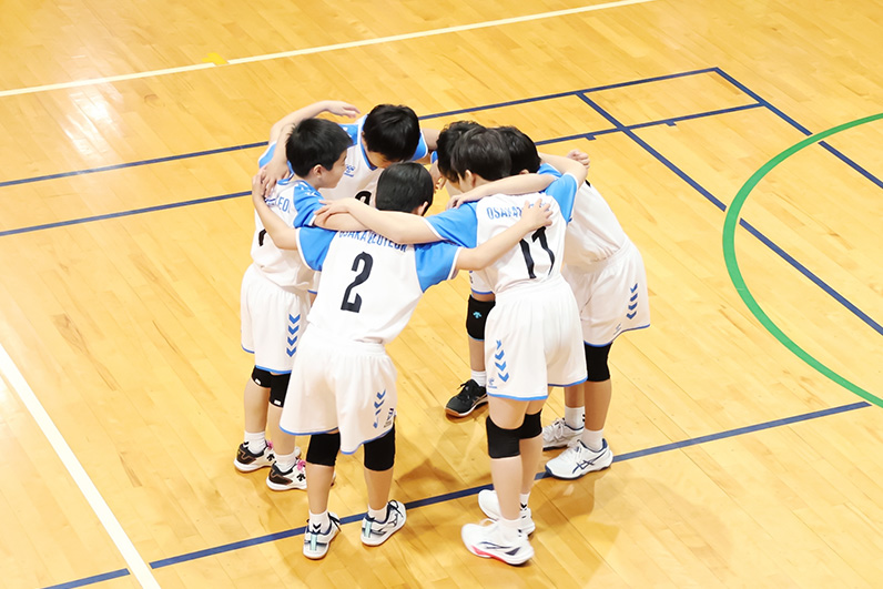 写真：コートで円陣を組む選手たち