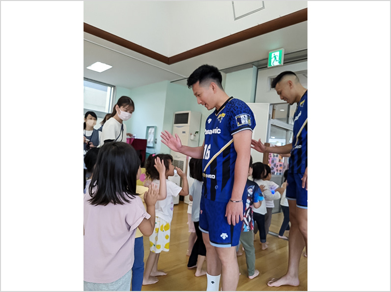 写真:ハイタッチする選手と子供たち