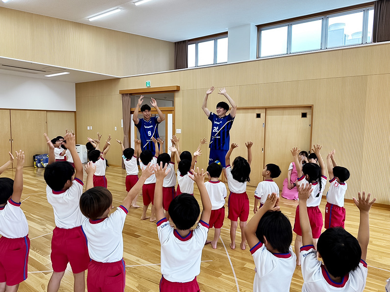 写真:指導する選手と練習する子供たち