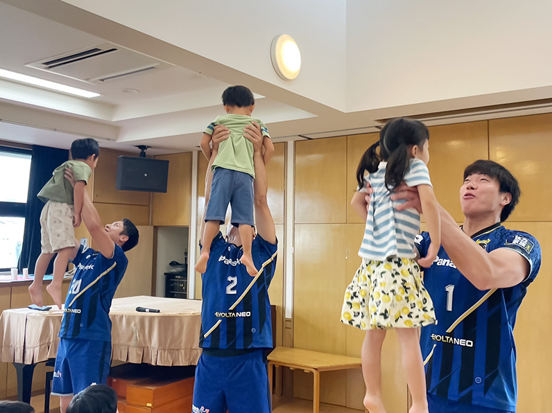 写真:子供を抱っこする選手たち