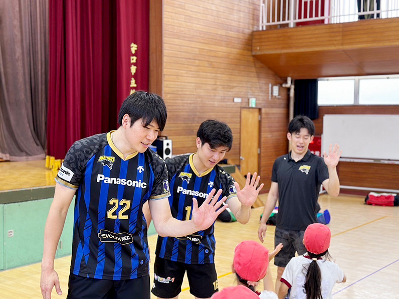 写真:ハイタッチする選手と子供たち