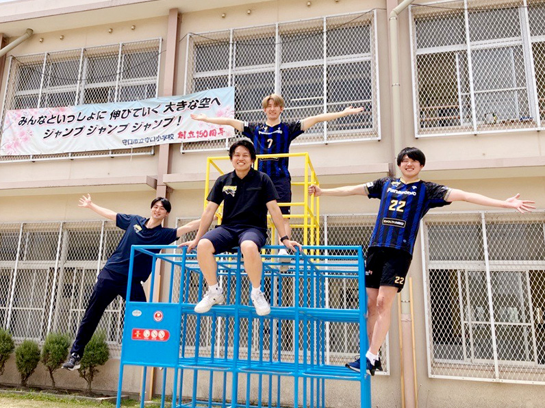 写真:ポーズをとる牧山マネージャー、岩沢アナリスト、垂水選手、小宮選手