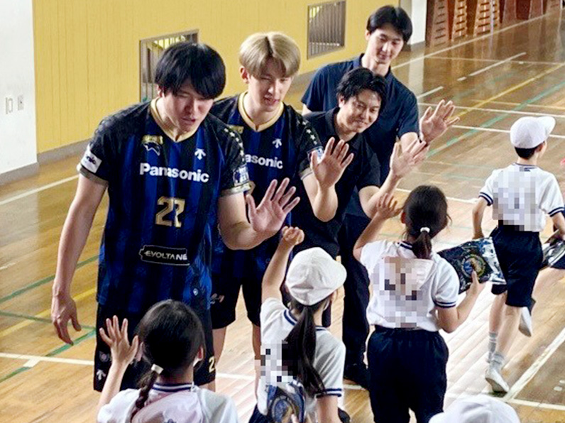 写真:ハイタッチする選手と子供たち