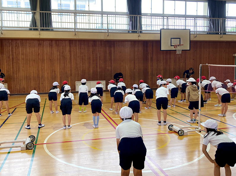 写真：準備運動をする選手と小学生たち