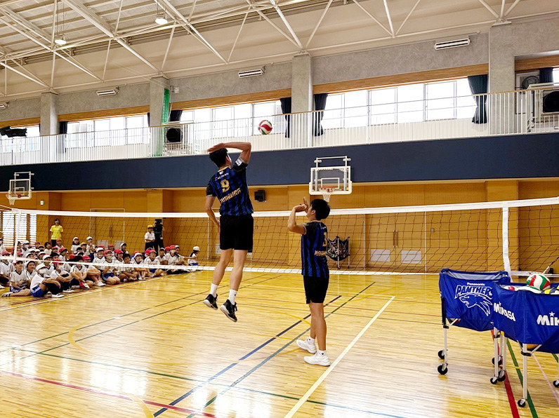 写真:お手本を見せる選手と見学する子供たち