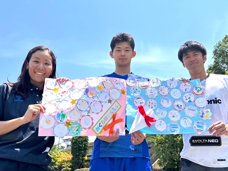 写真:ポーズをとる辻本通訳、西川選手、中村選手