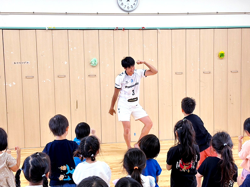 写真:ポーズをとる中村選手と真似をする子供たち