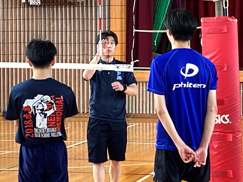 写真：説明をするコーチと聞いている子供たち
