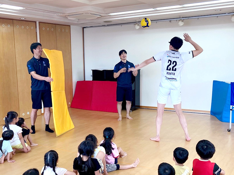 写真：見本を見せる選手と見学する子供たち