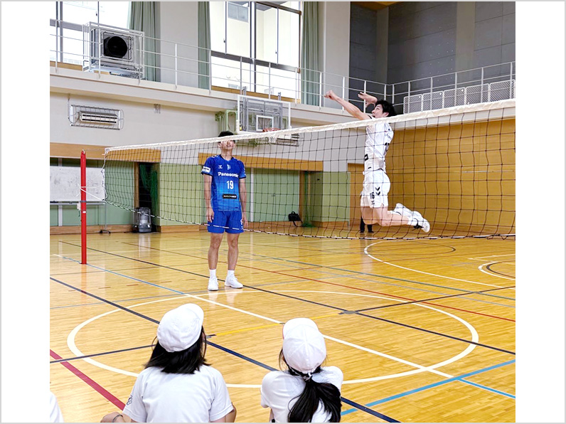 写真:お手本を見せる選手と見学する子供たち