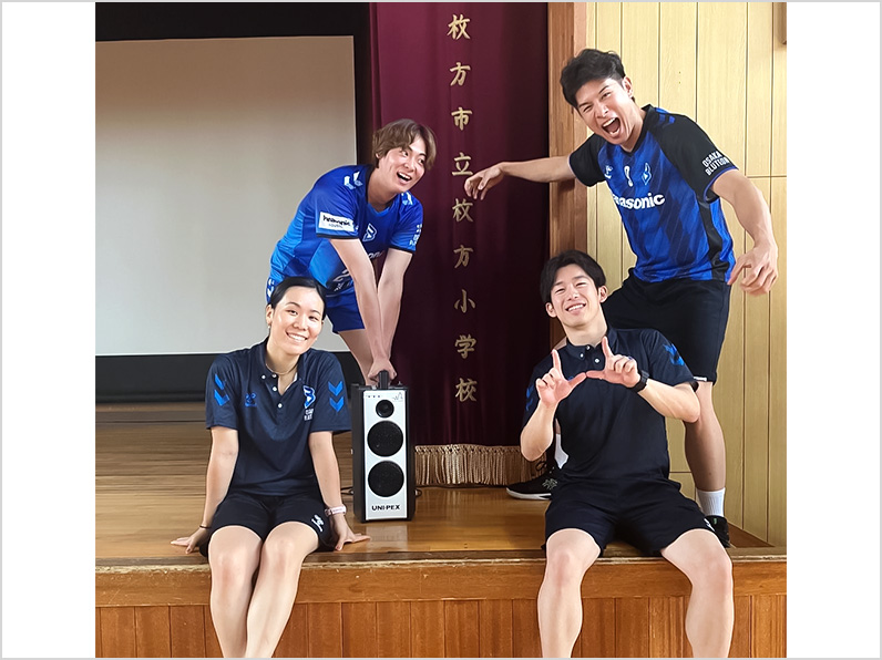 写真:ポーズをとる永露選手、今村選手、辻本通訳、山口コーチ