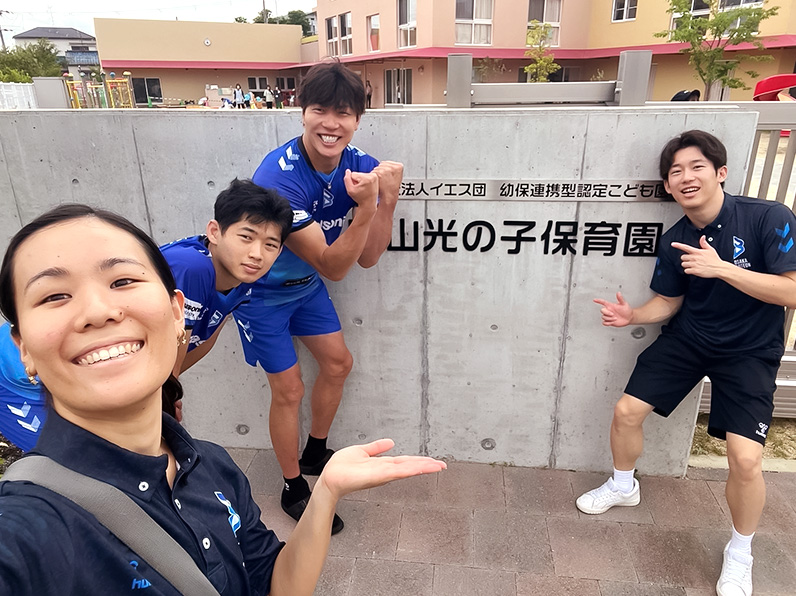 写真:ポーズをとる清水選手、西川選手、辻本通訳、山口コーチ