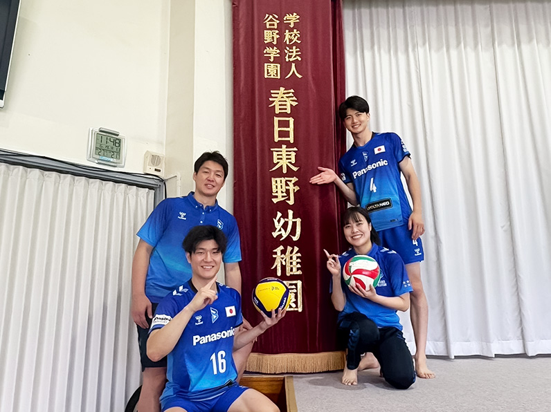 写真：学校名の前でポーズをとる白澤コーチ、池城選手、金田選手、伊藤マネージャー