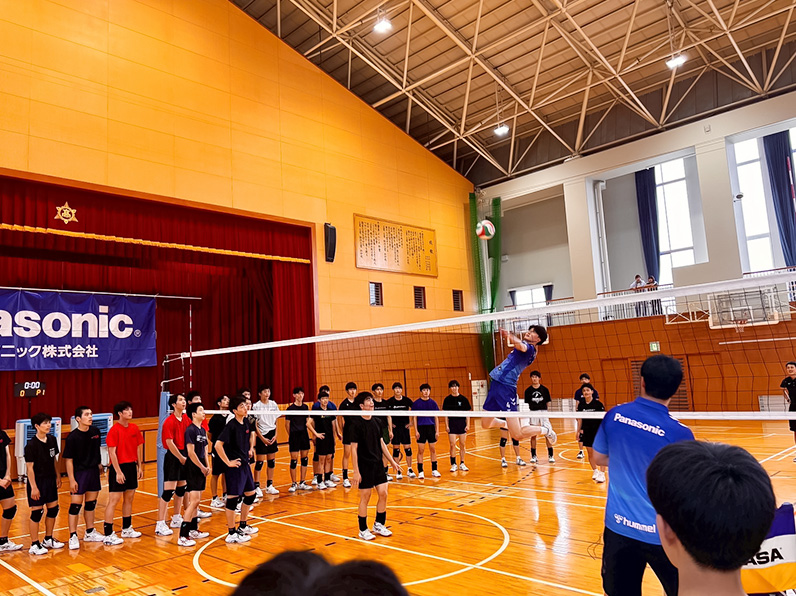 写真:お手本を見せる選手と見学する子供たち