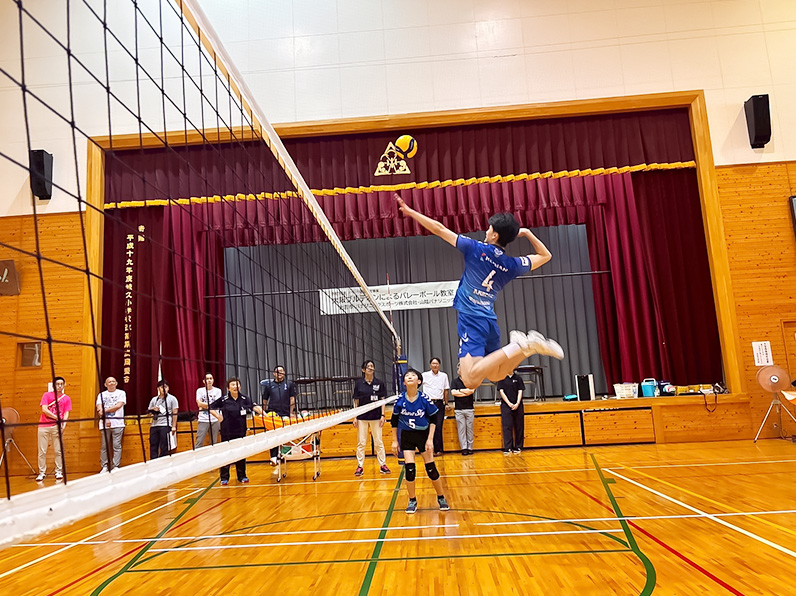 写真:お手本を見せる選手と見学する子供たち