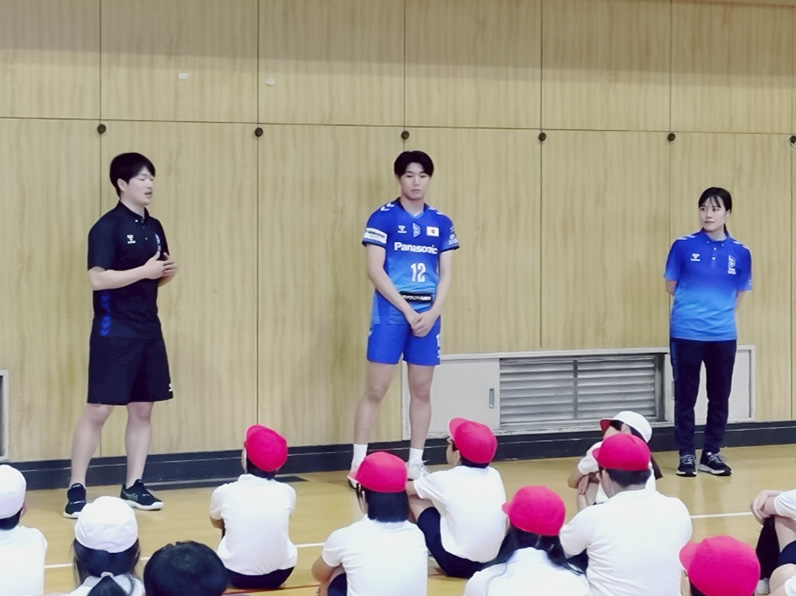 写真：話をするスタッフと座って聞いている子供たち