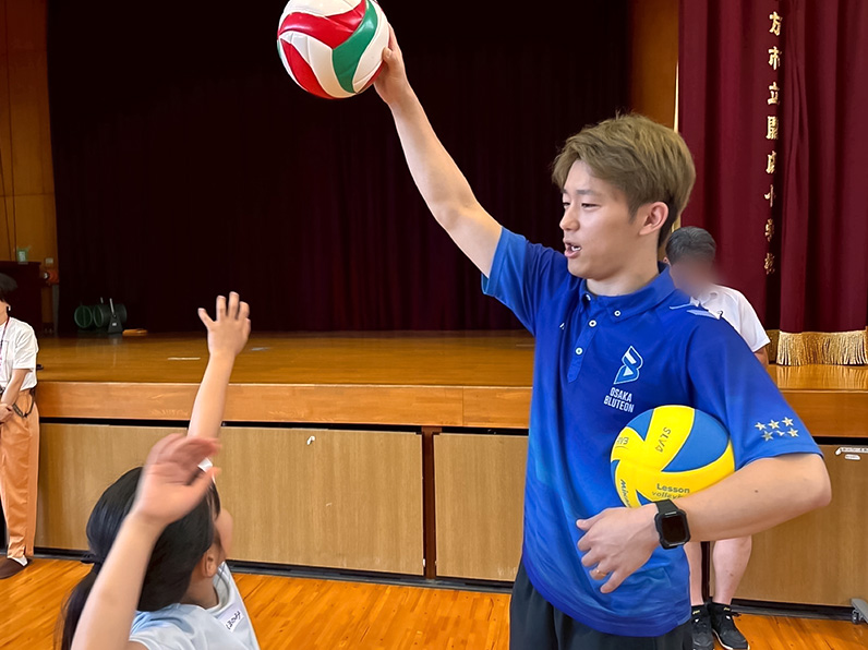 写真:お手本を見せる選手と見学する子供たち
