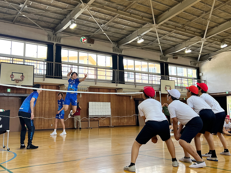 写真：子供たちにレクチャーをする白澤コーチ、仲本選手