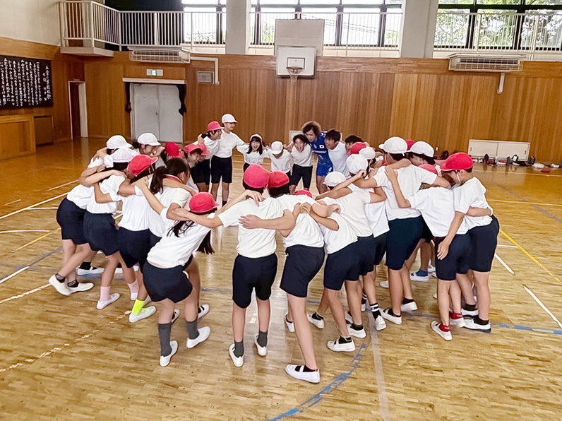 写真：子供たちにレクチャーをする白澤コーチ、仲本選手