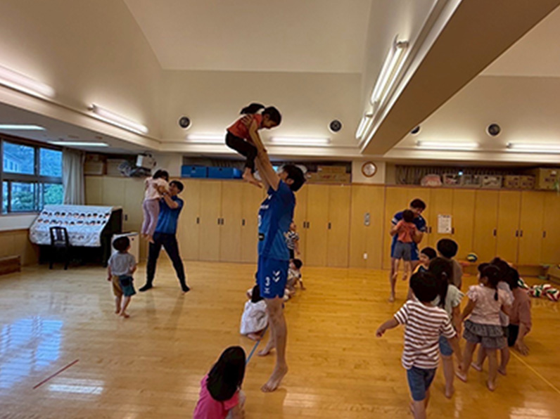 写真：子供たちと遊ぶ仲本 賢優選手、中村 駿介選手、牧山 祐介マネージャー