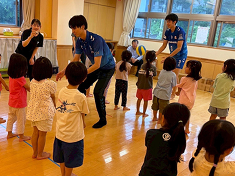 写真：子供たちと遊ぶ中村 駿介選手、牧山 祐介マネージャー