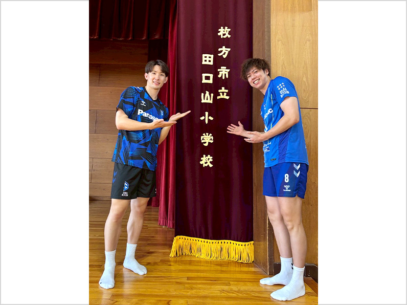 ภาพถ่าย: นักกีฬาทารุมิและนักกีฬานากาโมโตะโพสท่าหน้าชื่อโรงเรียน