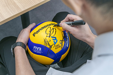 写真：バレーボールにサインをする西田選手